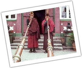 Monk blowing Alpenhorns